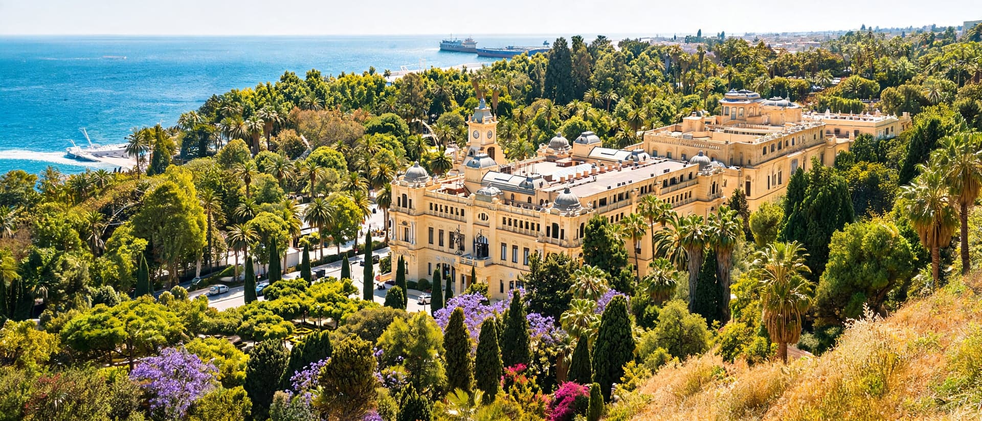 Luftaufnahme des Rathauses von Málaga mit Parkanlage und Küste