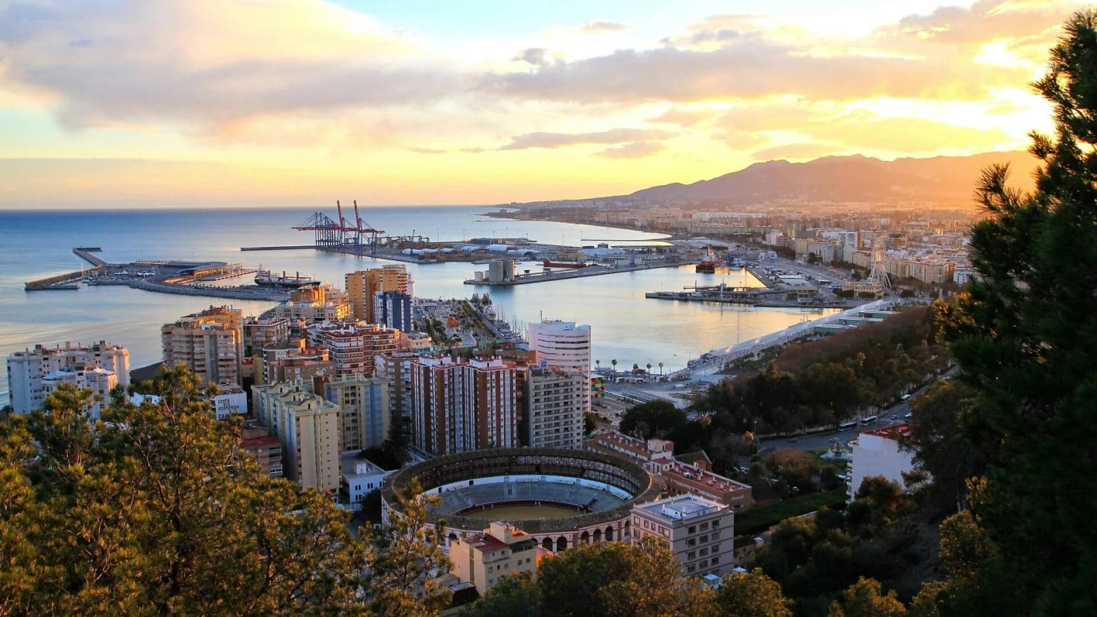 Hafen und Stierkampfarena von Málaga bei Sonnenuntergang