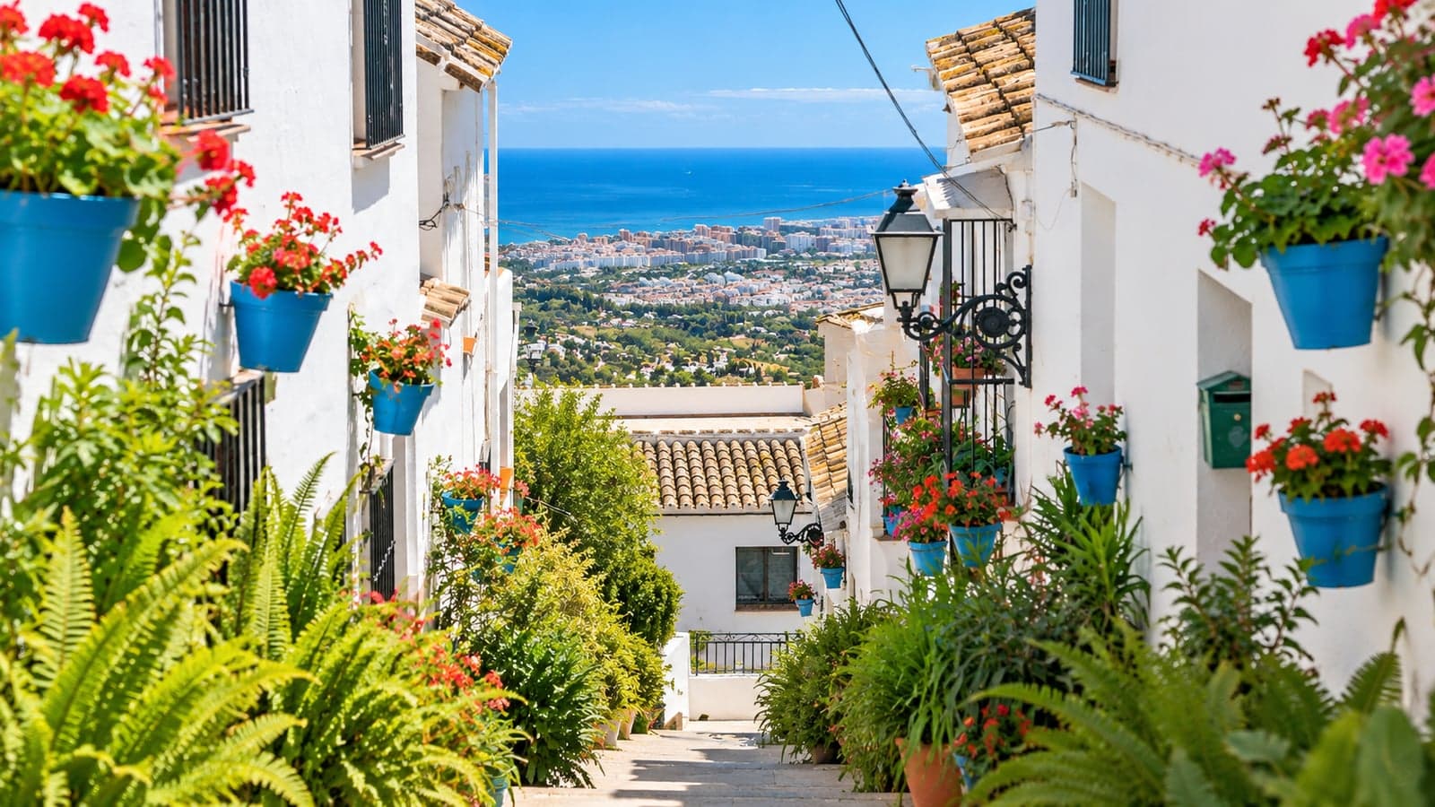 Blumengeschmückte Gasse mit Meerblick in Mijas Pueblo